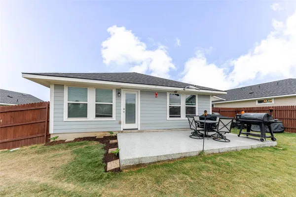 a view of a patio with table and chairs near a yard