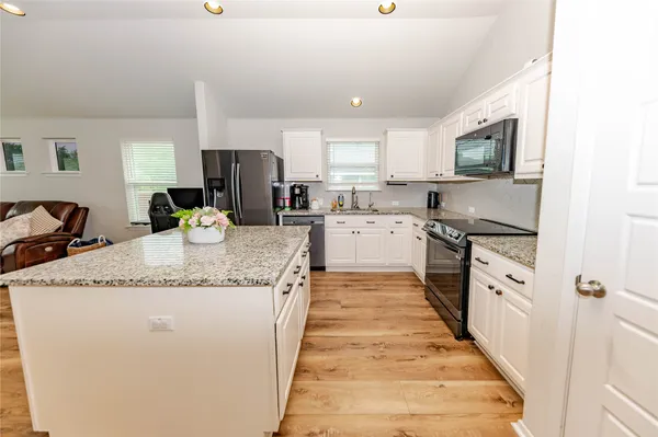 a large kitchen with stainless steel appliances granite countertop a stove sink and cabinets