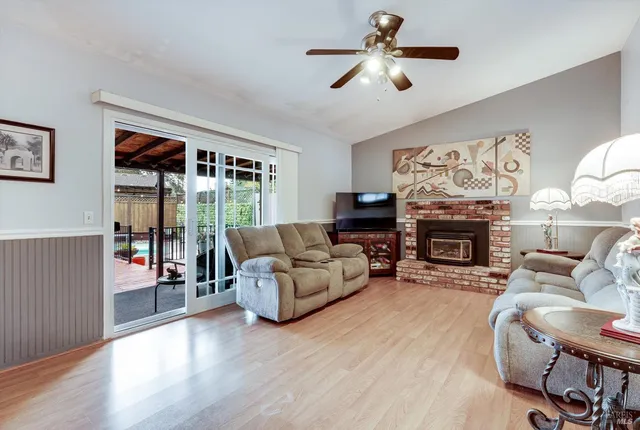 a living room with furniture a fireplace and a large window