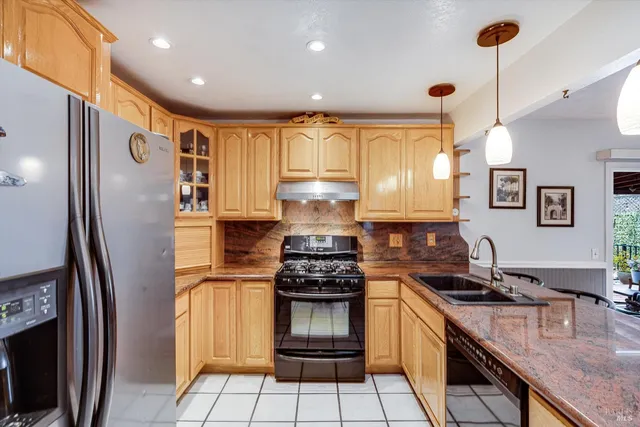 a kitchen with granite countertop a refrigerator stove and sink