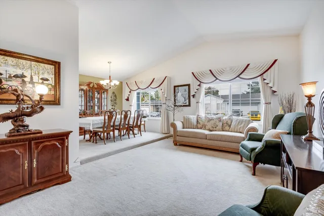 a living room with furniture a chandelier and a large window