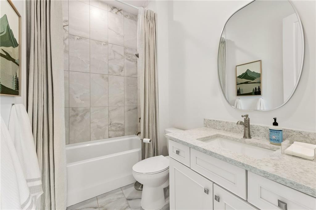 719 Crest Line Trail Powder Springs, GA 30127 - Photo 13 of 29 a bathroom with a granite countertop toilet sink and bathtub