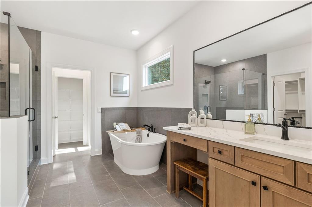 719 Crest Line Trail Powder Springs, GA 30127 - Photo 18 of 29 a spacious bathroom with a double vanity sink mirror and bathtub