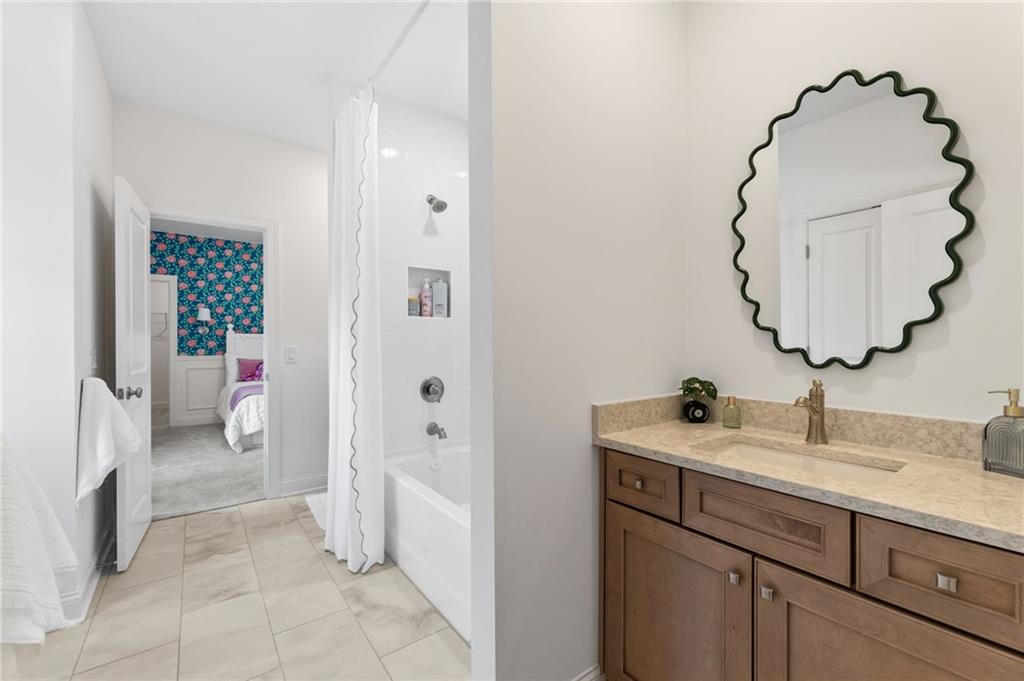 719 Crest Line Trail Powder Springs, GA 30127 - Photo 25 of 29 a en suite bathroom with a granite countertop sink a toilet and a mirror