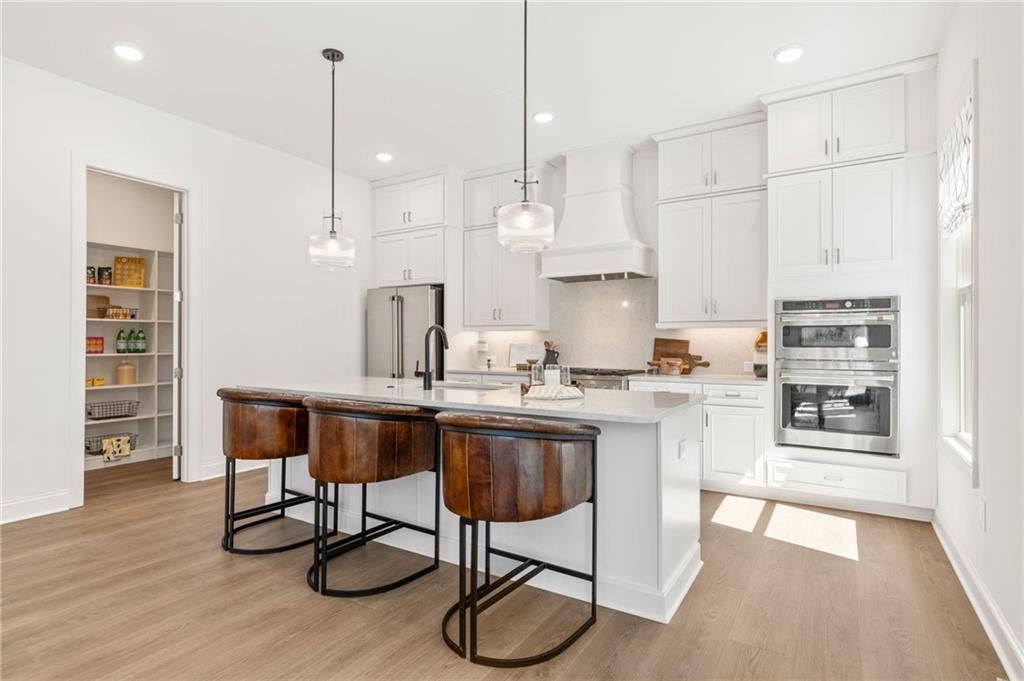 719 Crest Line Trail Powder Springs, GA 30127 - Photo 6 of 29 a kitchen with stainless steel appliances granite countertop a sink a stove a refrigerator and wooden floor