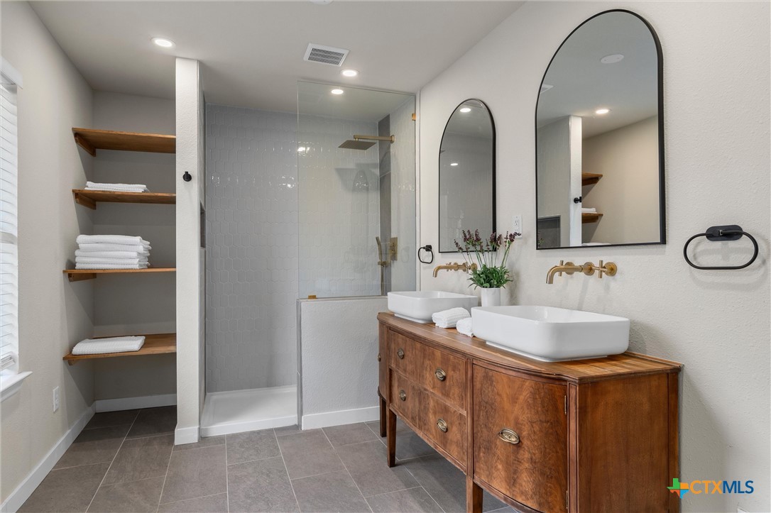 836 Cottle Town Road Smithville, TX 78957 - Photo 26 of 47 a spacious bathroom with a double vanity sink and a mirror