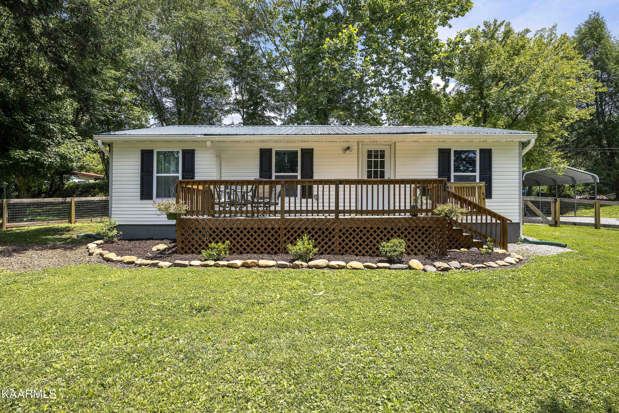 a view of a house with a big yard and large trees