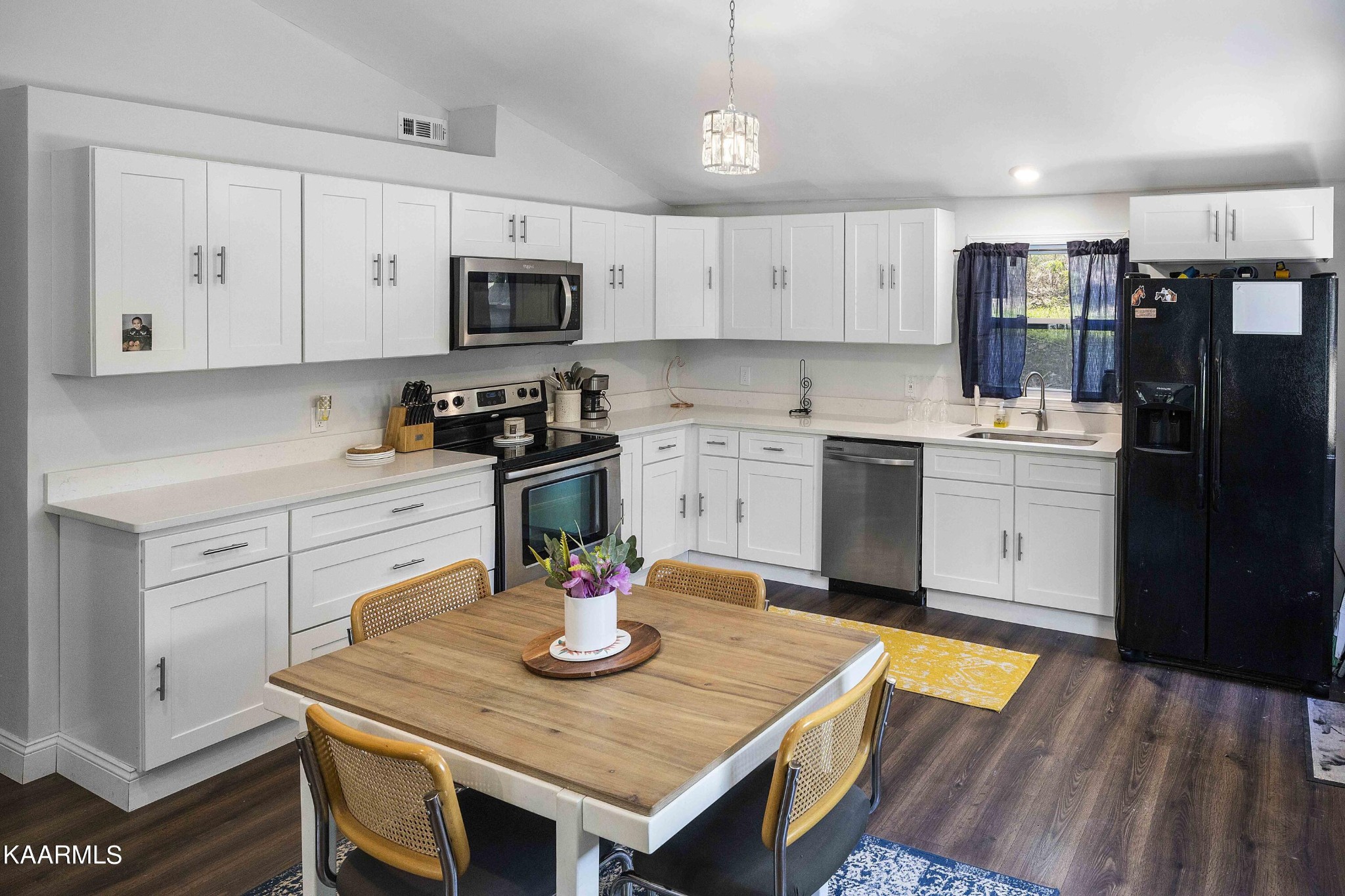 1000 Tarklin Valley Road Knoxville, TN 37920 - Photo 10 of 26 a kitchen with stainless steel appliances granite countertop a kitchen island a stove a sink dishwasher a dining table and chairs with wooden floor