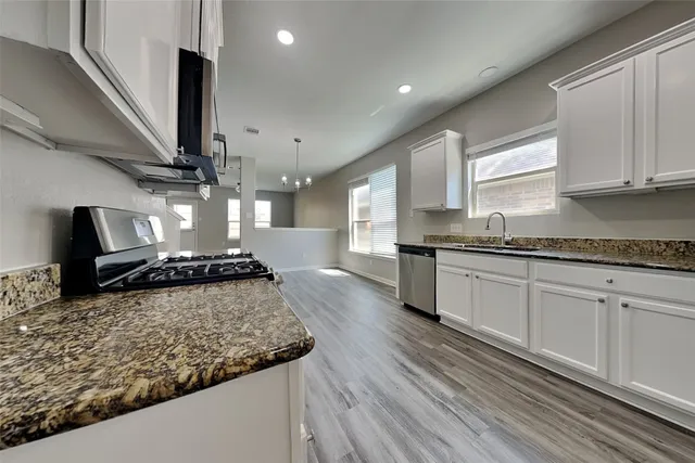 a kitchen with a stove a sink and a refrigerator