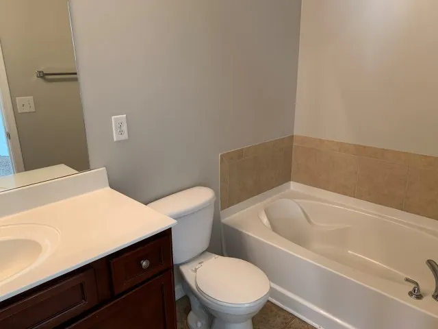 a white toilet sitting next to a bath tub