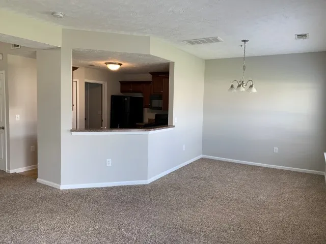 a view of a hallway with chandelier and entryway