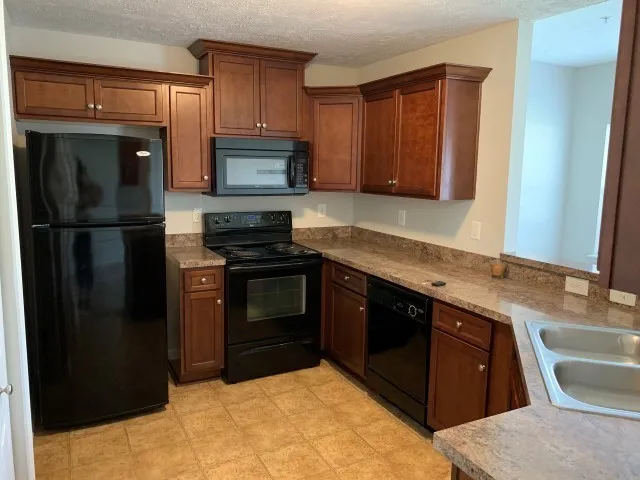 a kitchen with a sink stove and refrigerator