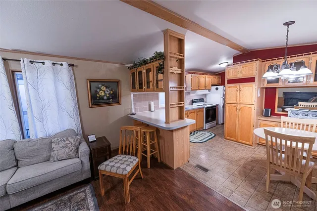 a living room with furniture and a dining table with wooden floor