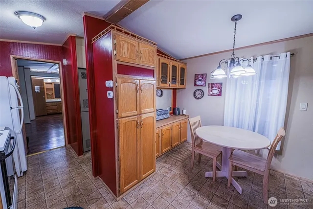 a kitchen that has a refrigerator a sink and chairs