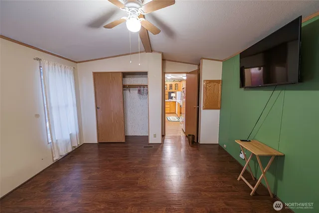 a view of a livingroom with wooden floor and a ceiling fan