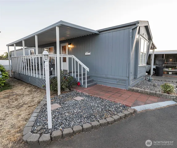 a view of a house with a small yard and wooden fence