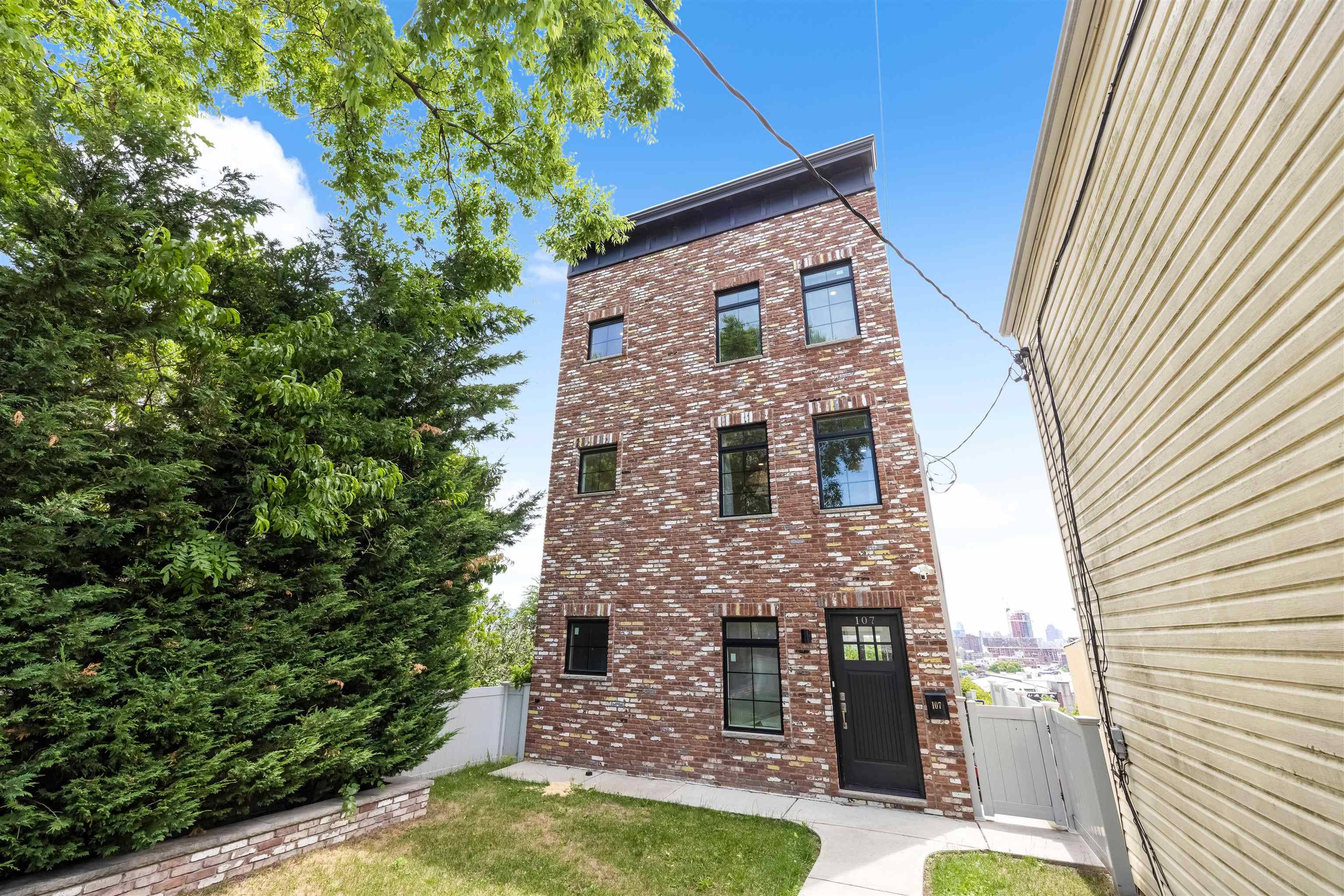 107 Mountain Road Jersey City, NJ 07307 - Photo 3 of 41 a front view of a house with a garden