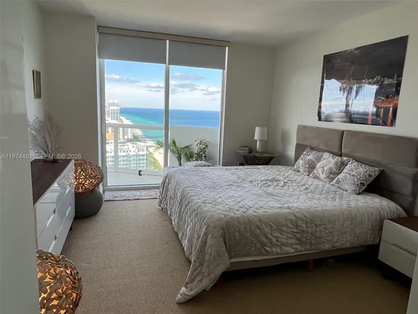 a bedroom with a bed and a dresser next to a window
