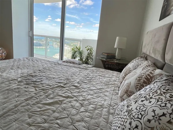 a large bed sitting in a bedroom next to a window