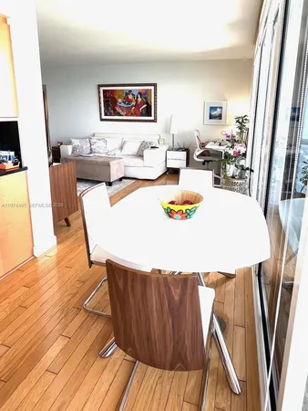 a living room with dining room and wooden floor