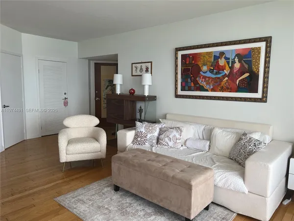 a living room with furniture and a painting on the wall