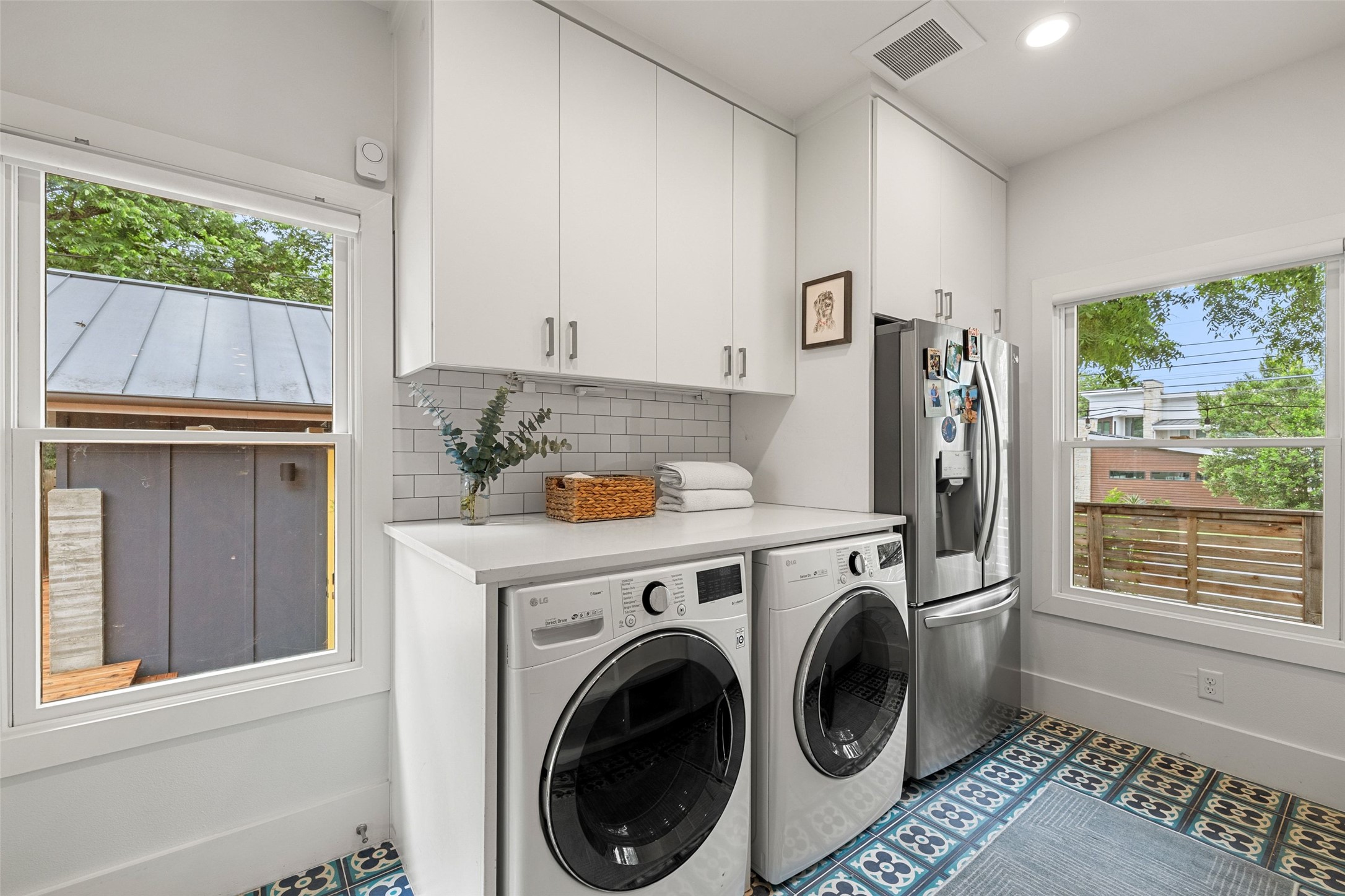 2000 Rundell Place Austin, TX 78704 - Photo 30 of 38 A well-appointed laundry area offers ample counter space, streamlined cabinetry, and cheerful patterned tile flooring.