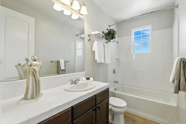 a bathroom with a granite countertop sink a toilet and shower