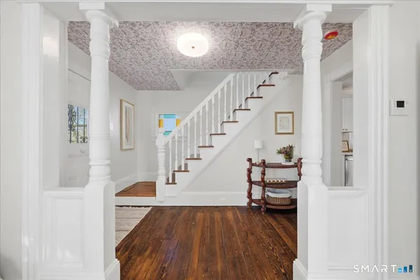 a view of entryway and hall with wooden floor