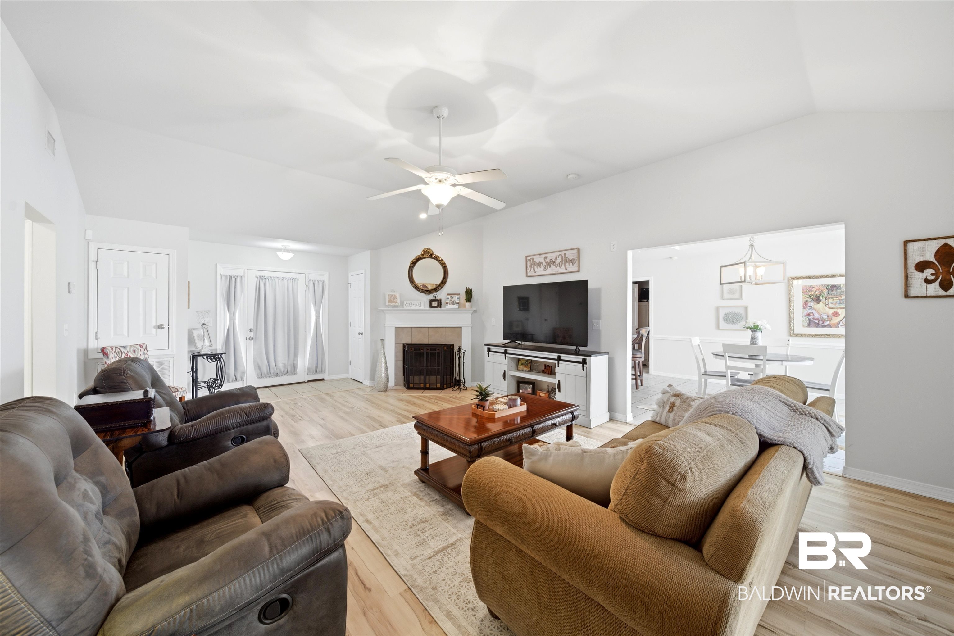 1901 Colorado Court Foley, AL 36535 - Photo 4 of 23 Living area featuring lofted ceiling, a tiled fireplace, ceiling fan, light wood-type flooring, and a chandelier