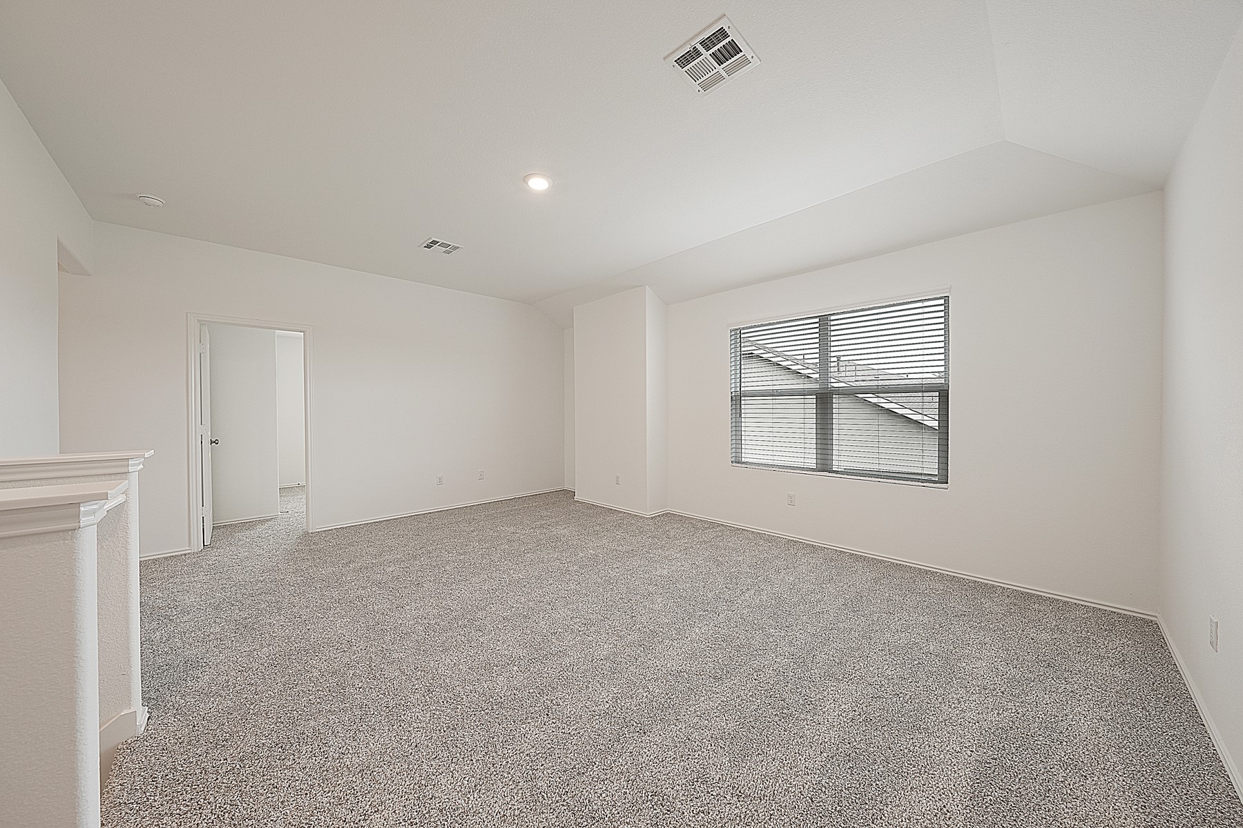 932 Mallow Road Leander, TX 78641 - Photo 25 of 34 A spacious room offers comfortable carpeting, recessed lighting, and a window with blinds for natural illumination.