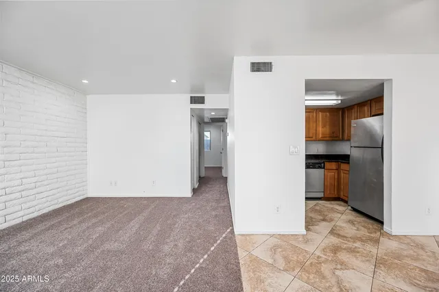 a view of a hallway with wooden floor and a kitchen