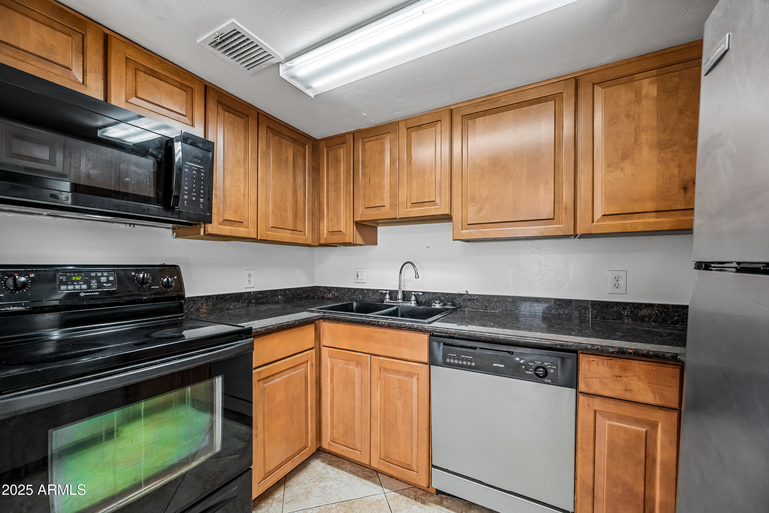 1234 North 36th Street, Unit 109 Phoenix, AZ 85008 - Photo 8 of 16 a kitchen with stainless steel appliances granite countertop a stove a sink and a microwave