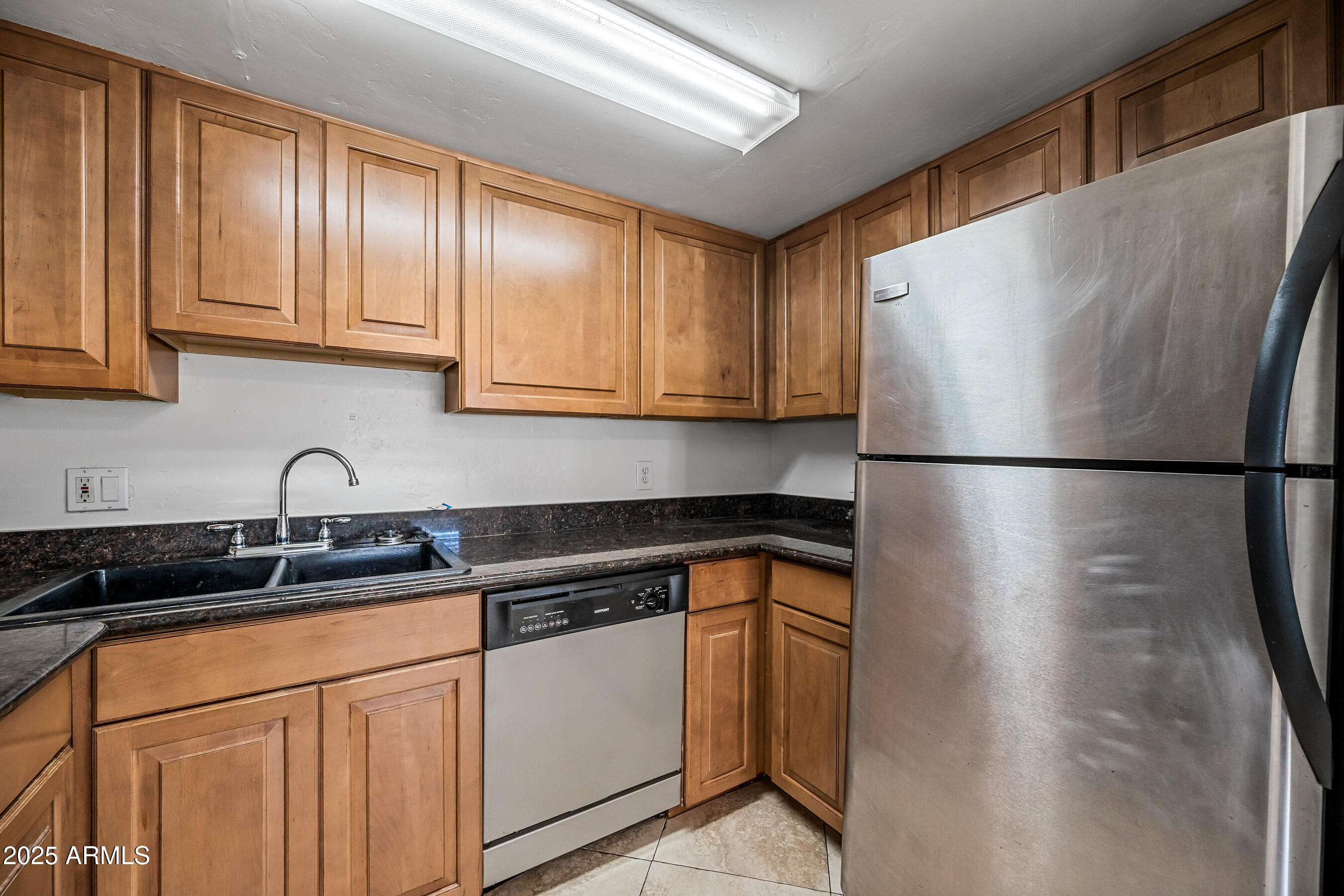 1234 North 36th Street, Unit 109 Phoenix, AZ 85008 - Photo 9 of 16 a kitchen with stainless steel appliances granite countertop a sink a refrigerator and cabinets
