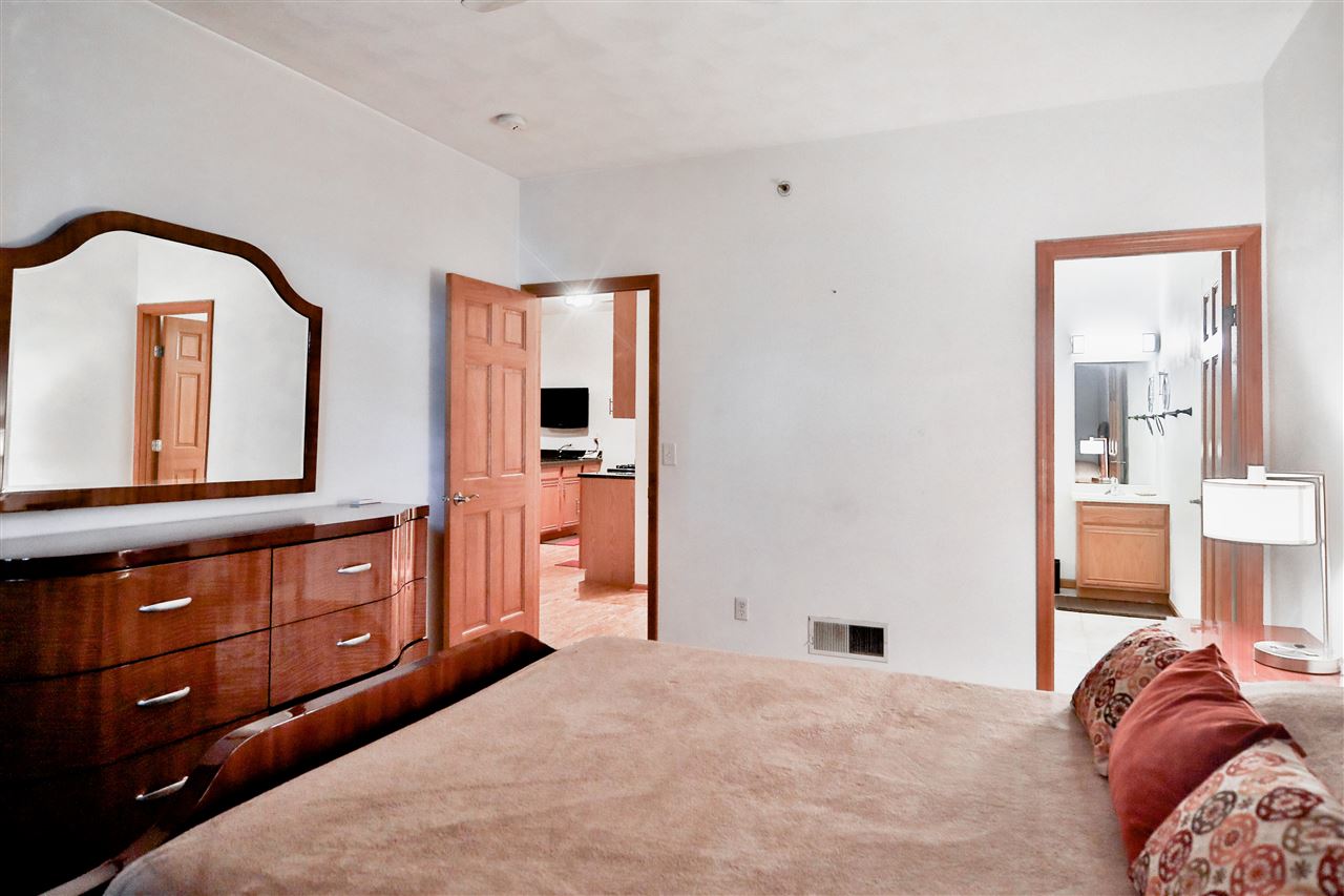 10135 Monarch Road, Unit 3 Roscoe, IL 61073 - Photo 13 of 20 a bedroom with a bed a dresser and mirror