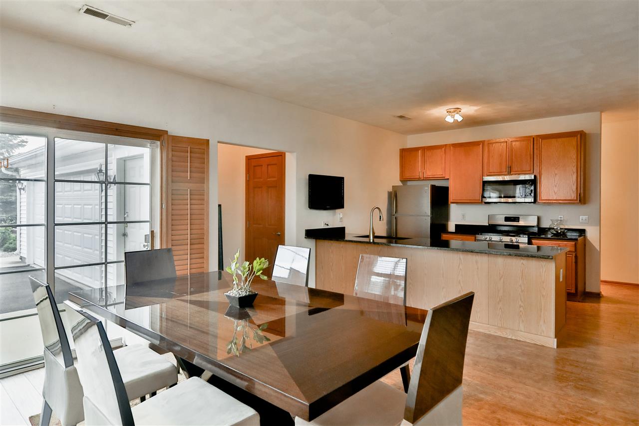 10135 Monarch Road, Unit 3 Roscoe, IL 61073 - Photo 7 of 20 a living room with stainless steel appliances a dining table and chairs