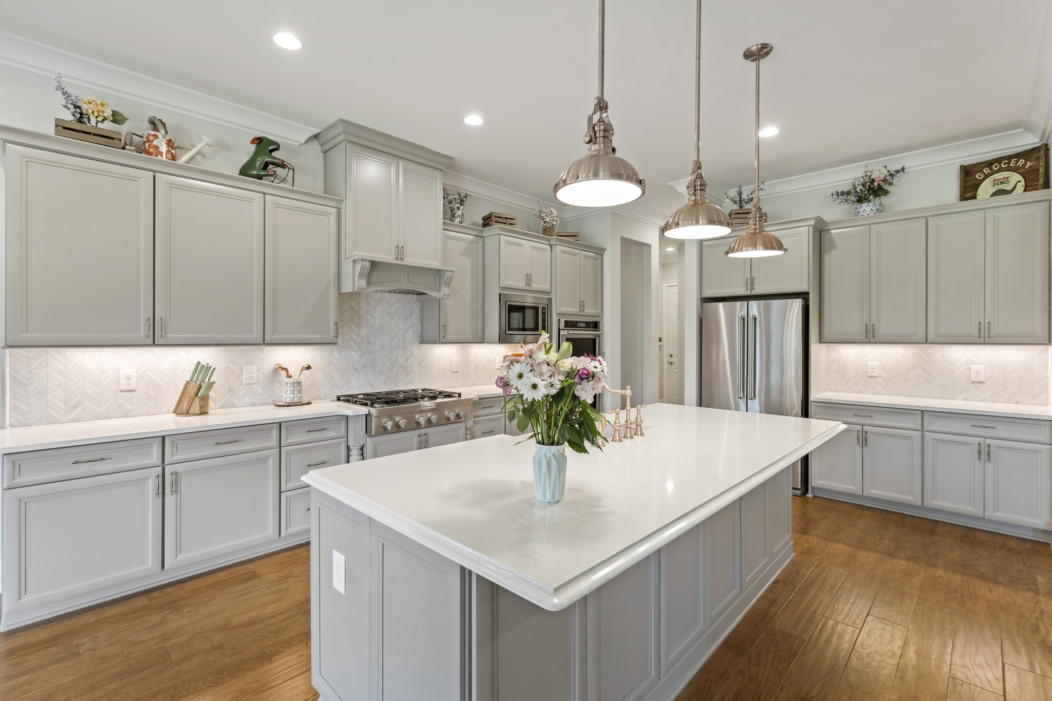 7952 Daugherty-Capley Road Primm Springs, TN 38476 - Photo 13 of 44 a kitchen with a white center island a sink stainless steel appliances and cabinets