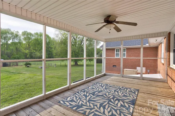 a view of a porch with a table and chairs
