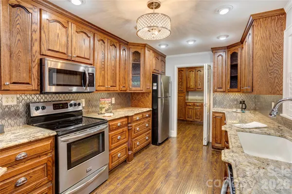 a kitchen with stainless steel appliances kitchen island granite countertop a stove a sink and a microwave