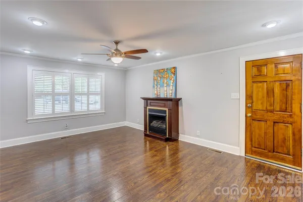 an empty room with windows and chandelier fan