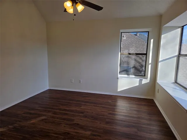 a view of an empty room with wooden floor