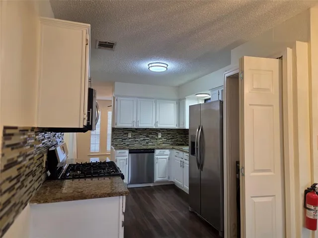 a view of a livingroom with a flat screen tv wooden floor and a ceiling fan