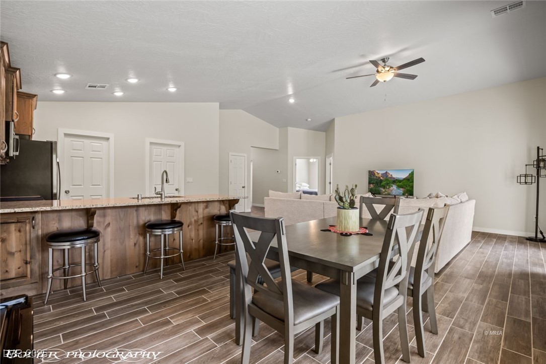 942 Shadow Hawk Ridge Mesquite, NV 89027 - Photo 26 of 67 Dining space with wood finish floors, ceiling fan, lofted ceiling, baseboards, and recessed lighting