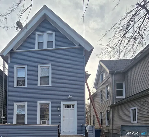 a front view of a house with a tree