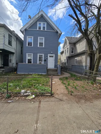a view of a brick house with many windows next to a road