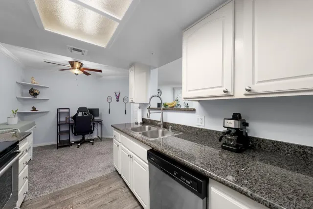 a kitchen with stainless steel appliances granite countertop a sink dishwasher stove and microwave with wooden floor