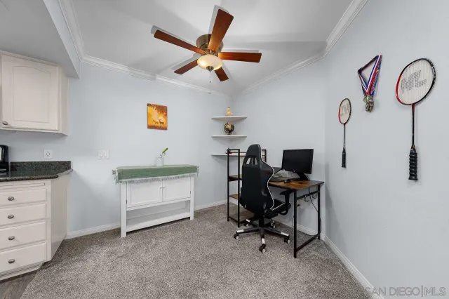 a view of a workspace with furniture and a ceiling fan