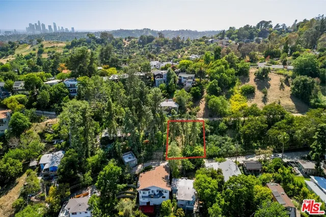 an aerial view of residential house with outdoor space and trees all around