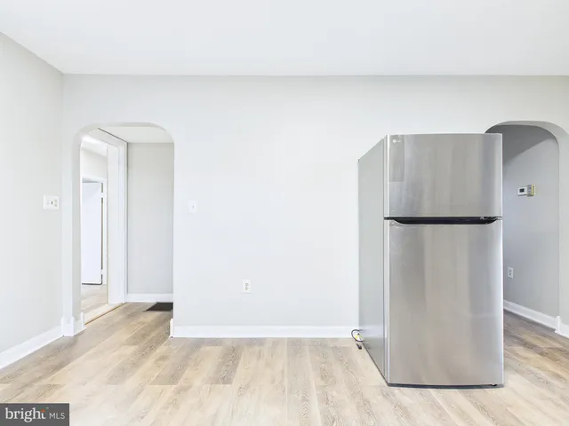 a view of empty room with wooden floor and fireplace