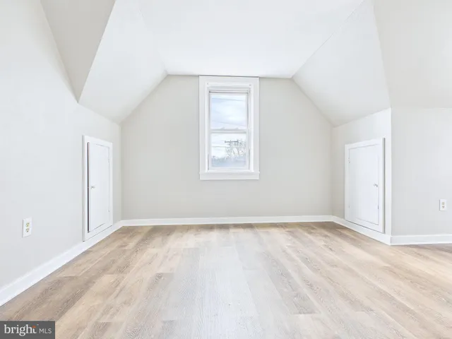 an empty room with wooden floor ceiling fan and window