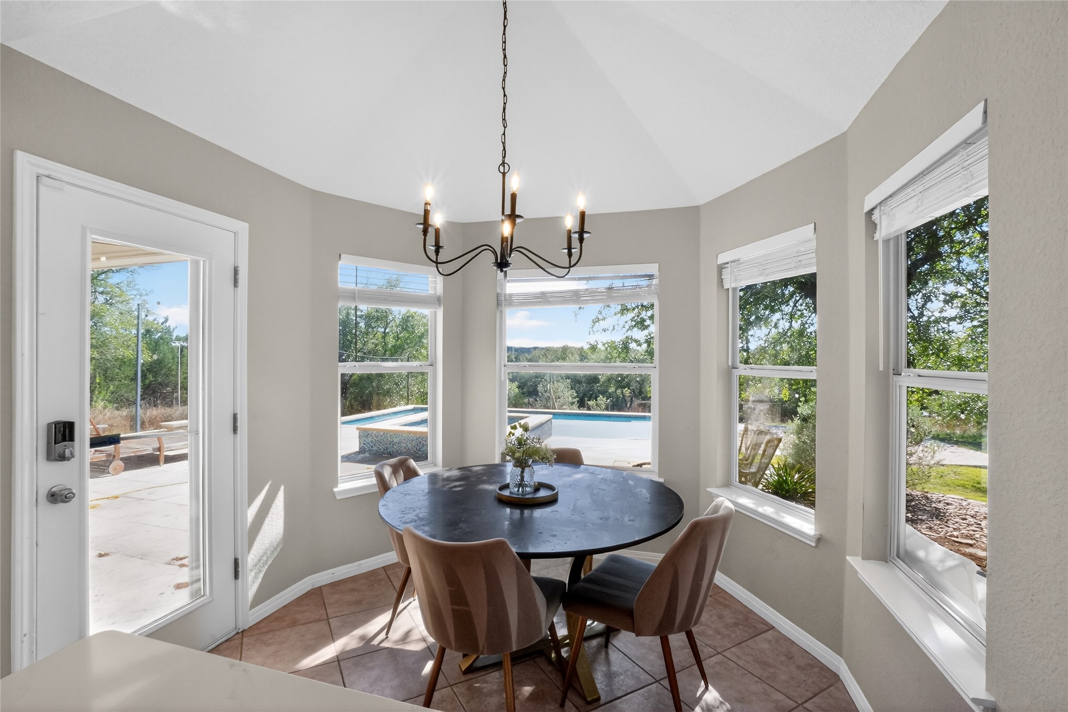 13624 Trautwein Road Austin, TX 78737 - Photo 11 of 38 A well-lit breakfast area offers panoramic views of the adjacent pool and natural surroundings.